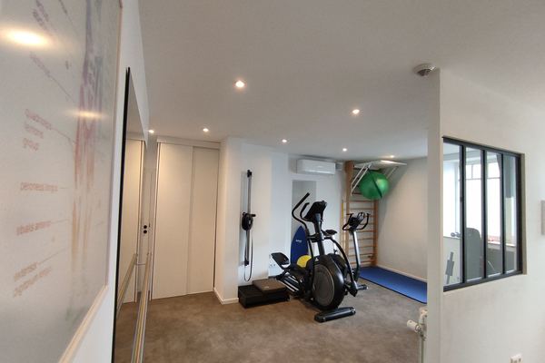 Espace de rééducation avec miroir mural et barre de marche